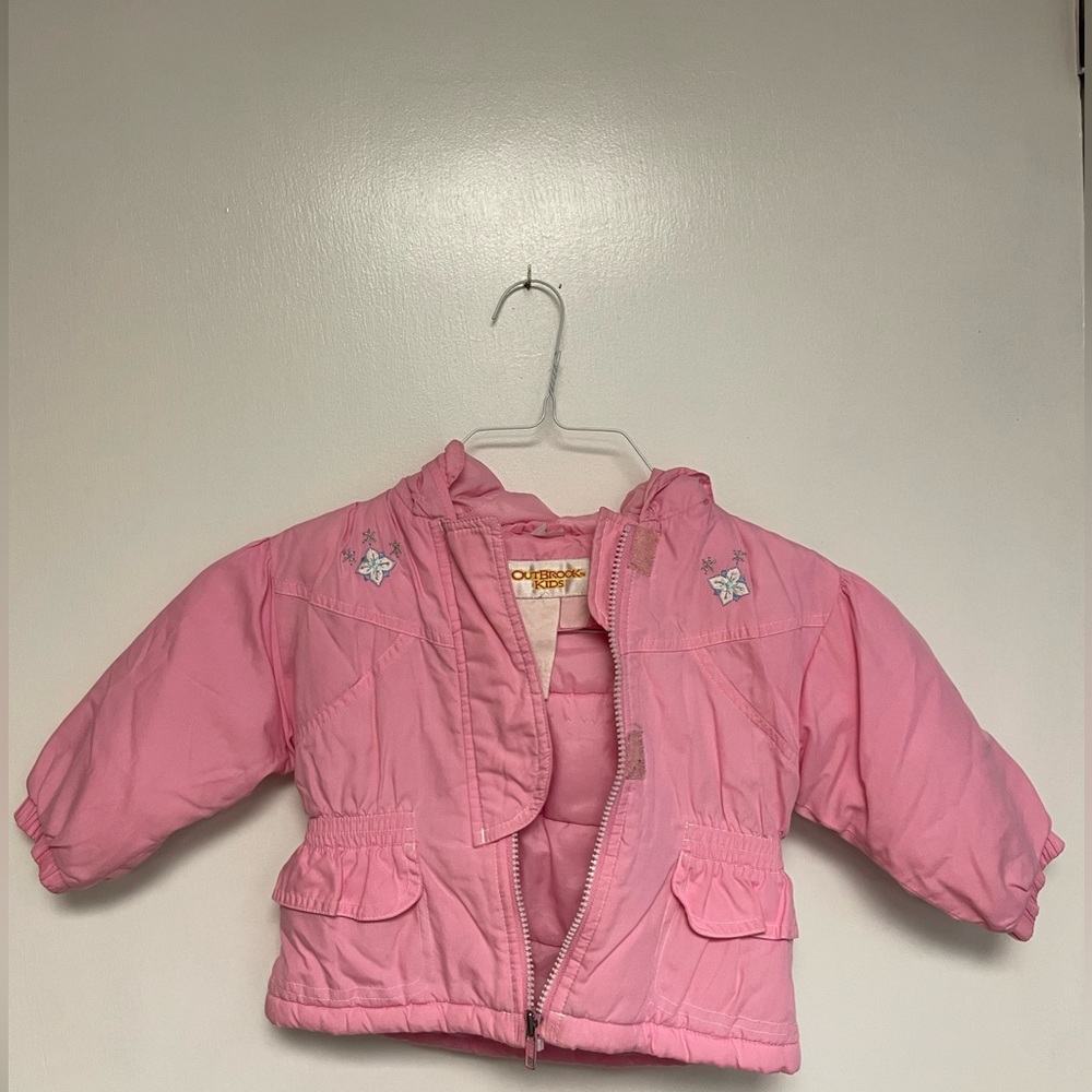 Pink winter Outbrook kids jacket with designs, pockets, and hood.